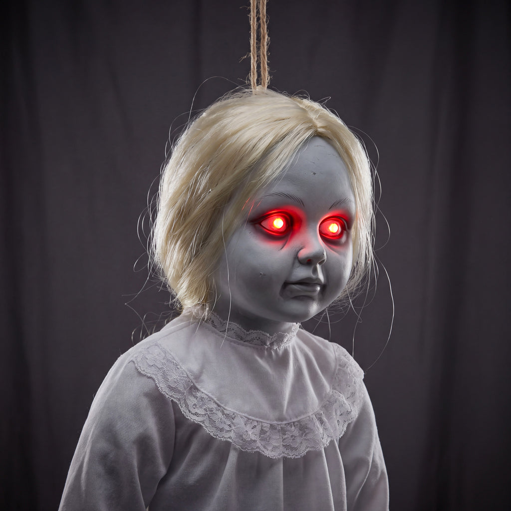 Close-up detail of the decoration's glowing red LED eyes and the white lace collar trim