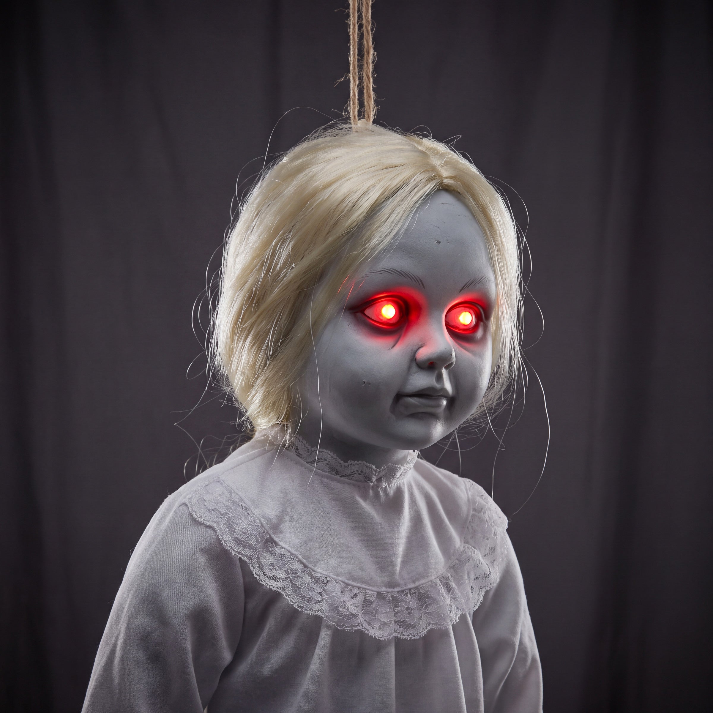Close-up detail of the decoration's glowing red LED eyes and the white lace collar trim